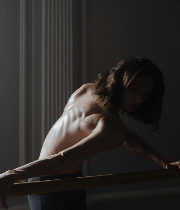 Person practicing gentle movements for flexibility in a dark room